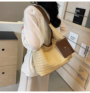 Close-up of straw tote bag with brown leather strap and matching mini coin purse
