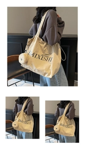 Detail of beige canvas tote bag with a small matching round coin purse and black text