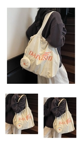 Detail view of canvas tote bag showing the side zipper pouch and drawstring closure
