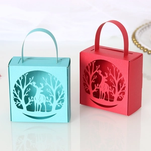 Detail of laser-cut reindeer and forest patterns on blue and red Christmas candy gift boxes