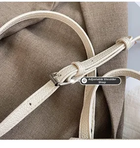 Détail de la bandoulière réglable en cuir grainé avec boucle en métal argenté du sac crème
