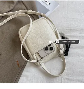 Détail de la poche arrière d'un sac blanc en cuir litchi contenant un smartphone