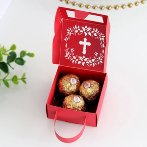 Detailed laser-cut hollow cross design on a red paper gift box with handle