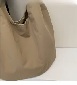 Dettaglio della borsa tote kaki grande con tessuto morbido e design rilassato