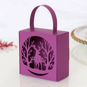 Detail of laser-cut reindeer forest design on premium dark purple paper gift box