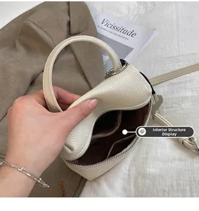 Détail de l'intérieur d'un sac beige en cuir grainé avec fermeture et compartiment