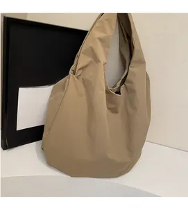 Dettaglio della borsa tote in tela kaki con trama di tessuto plissettato morbido