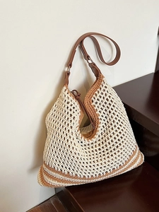 Minimalist woven straw tote bag with brown leather straps for beach or daily summer use
