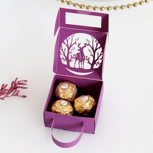 Detail of purple laser-cut reindeer gift box with golden chocolate pralines inside
