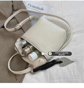 Vue intérieure montrant la capacité du sac bandoulière crème pour téléphone et cosmétiques