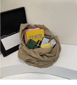 Dettaglio dell'ampia capacità della borsa tote kaki a pieghe con vari oggetti