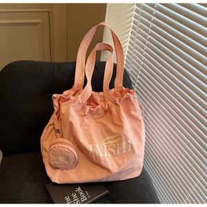 Pink oversized tote bag with drawstring closure and matching round coin purse charm