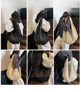 Dettagli di una borsa tote grande in tela indossata da una modella in kaki e nero
