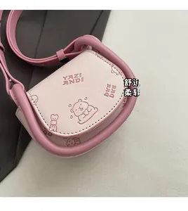 Detailed side view of a pink mini saddle bag featuring a cute cartoon bear pattern