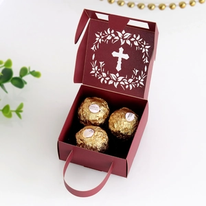 Detail of laser-cut cross and floral patterns on elegant burgundy paper gift box
