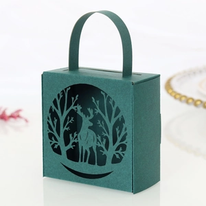 Detail of laser-cut forest deer pattern on dark green Christmas gift box with handle