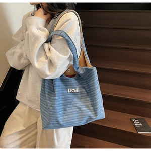 Lifestyle view of large capacity blue striped canvas tote bag with LOVE patch details