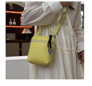 Vue détaillée du mini sac bandoulière jaune citron en cuir grainé avec breloque cœur