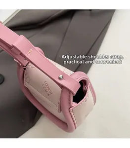 Detail of adjustable strap with metal studs and cute bear print on pink saddle bag