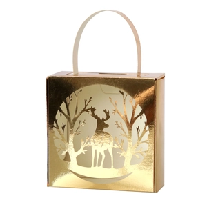 Detail of golden laser-cut Christmas candy box with reindeer and forest patterns