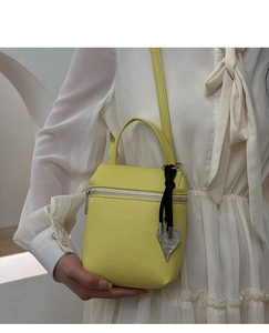Détail du mini sac en cuir jaune citron avec pendentif cœur et fermeture éclair métal