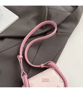 Detail of adjustable pink leather shoulder strap on mini saddle bag with bear motif