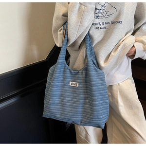 Detail showing the blue corduroy texture and LOVE label of this large tote shoulder bag