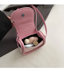 Internal view of a small saddle bag showing storage capacity for lipstick and compact powder