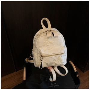 Detail of cream mini backpack with white lace patterns and 3D butterfly decorations