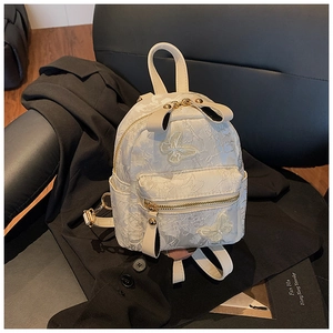 Detail of cream embroidered backpack with floral texture and 3D butterfly appliqué