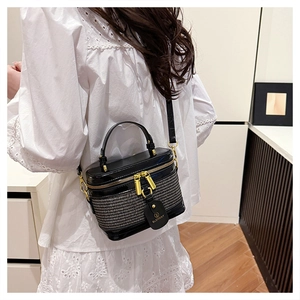 Detail of tweed and patent leather crossbody box bag with gold-tone hardware and tag