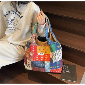 Detail of bohemian tote bag with colorful patchwork patterns and 'LOVE' woven label