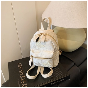 Detailed close-up of a white lace mini backpack featuring 3D butterfly floral appliqués