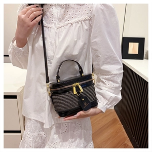 Detail of a chic black textured box bag with gold metal hardware and brand logo tag