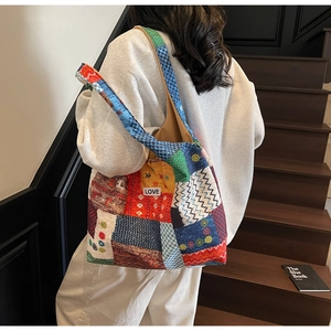 Detailed view of colorful patchwork tote bag with LOVE label shown on a model