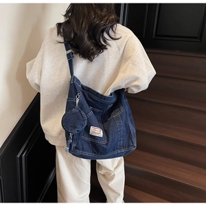 Detail view of large denim tote bag with side pockets and matching round coin purse pouch