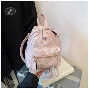 Detail of light pink mini backpack with floral butterfly embroidery and gold zippers