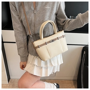 Détail du sac seau blanc crème avec garniture marron et fermoir rotatif en métal