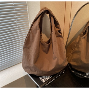 Dettaglio della borsa tote marrone caffe con trama in tessuto plissettato naturale
