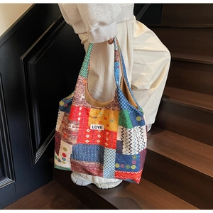 Detail of multi-color patchwork tote bag with LOVE patch and vibrant floral patterns