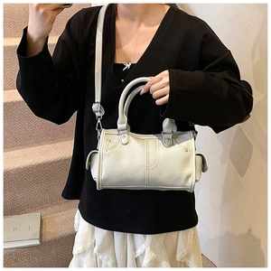 Borsa a bauletto bianco crema con trama a litchi indossata a spalla da modella