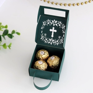 Detail of dark green hollow cross gift box with laser-cut design and paper handle