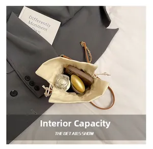 Detail view of beige drawstring bucket bag interior holding phone and perfume