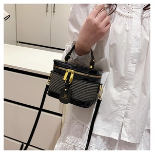Close-up of dual-zipper closure and woven texture on black box-style handbag