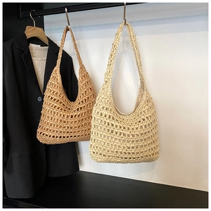 Detail of hollow out crochet pattern on large capacity straw hobo shoulder bag for beach