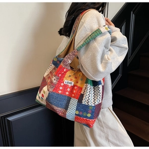 Close-up of colorful patchwork canvas tote bag with LOVE patch and geometric patterns