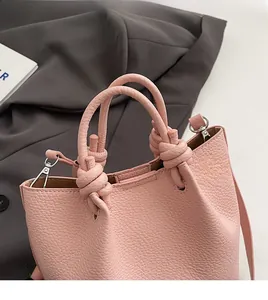 Detail of pink lychee textured bucket bag featuring unique double knotted handles