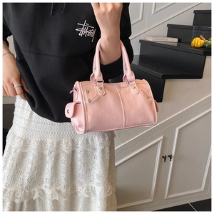 Dettaglio borsa boston rosa in pelle martellata con finiture di borchie argentate