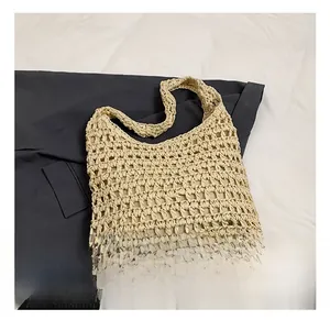 Detailed close-up of hollow woven pattern and texture on a beige straw beach tote bag