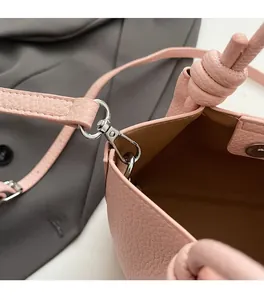 Close-up of silver metal hooks and magnetic clasp on pink pebble leather bucket bag